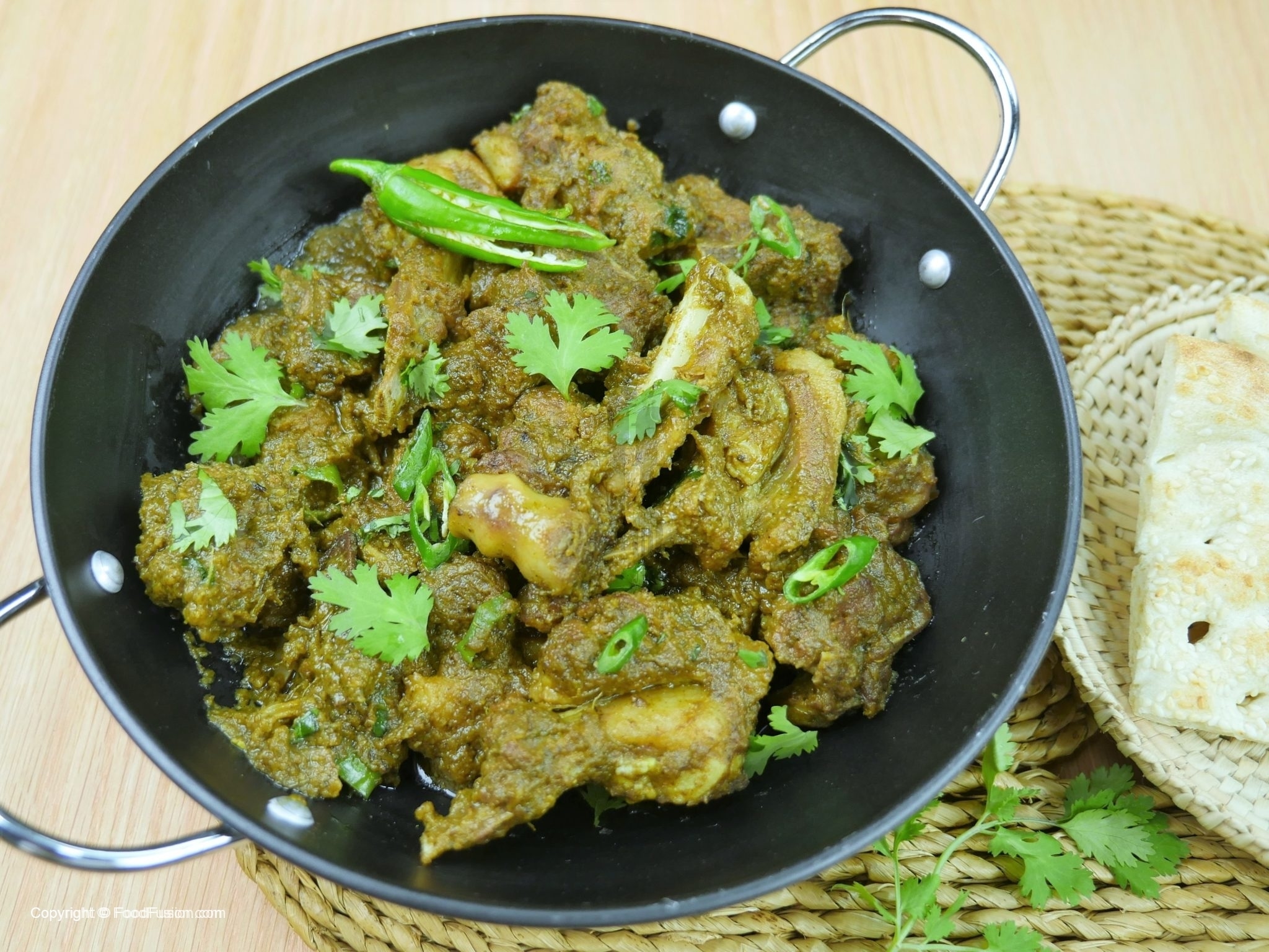 A serving bowl of green masala chicken