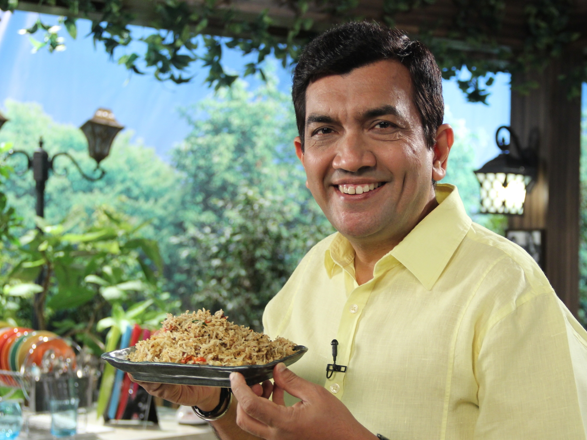 Television chef Sanjeev Kapoor holding a plate of rice.
