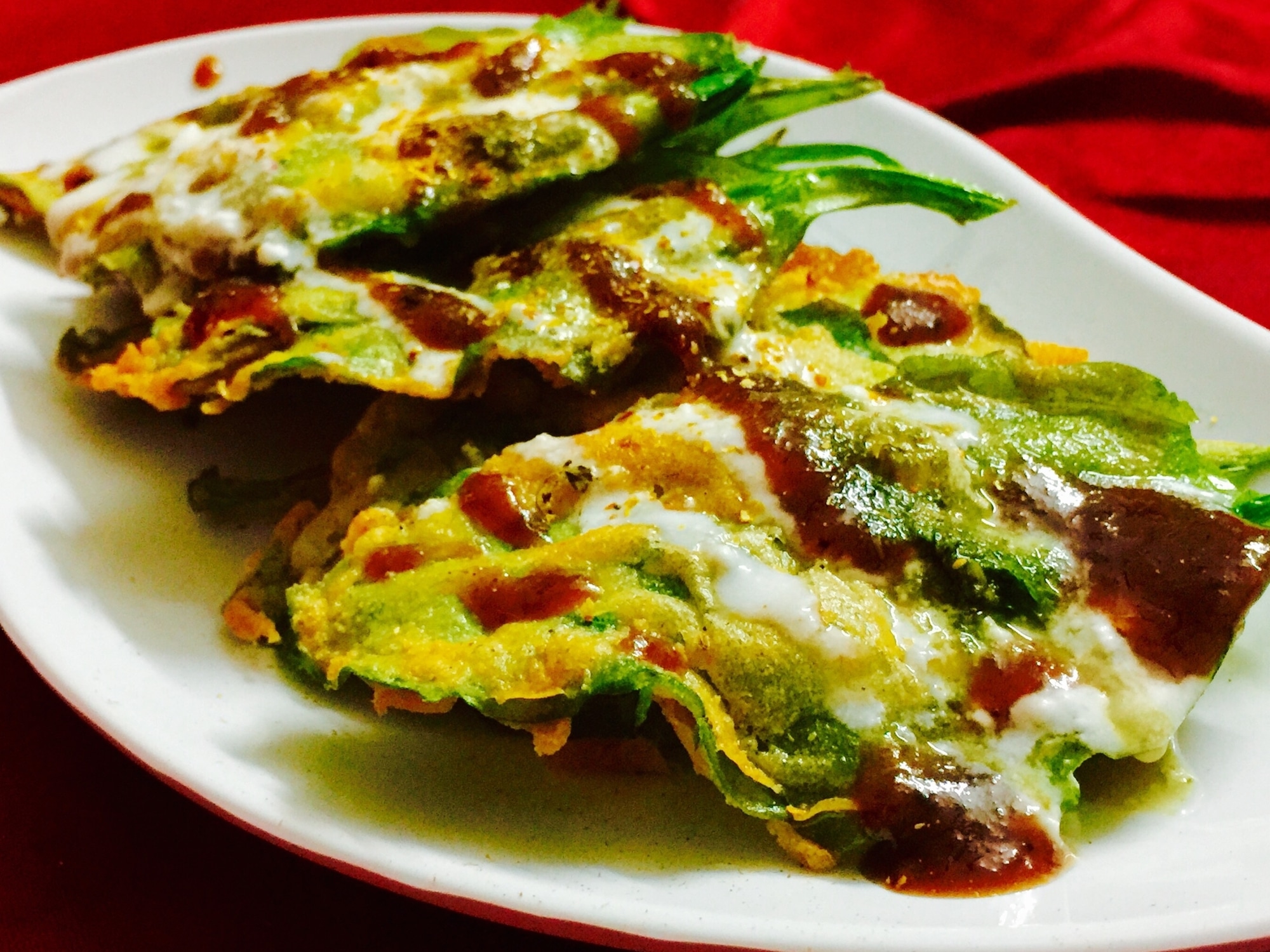 a serving plate of crisp fried spinach with chaaat dressings