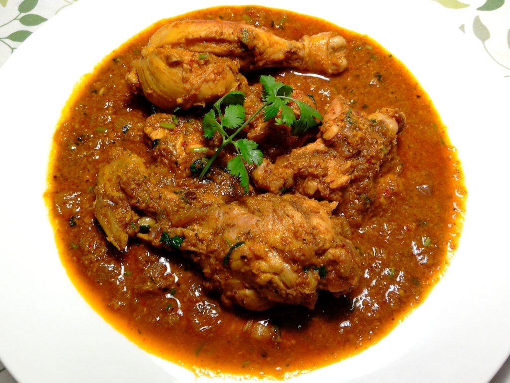 a serving bowl of chicken xacuti