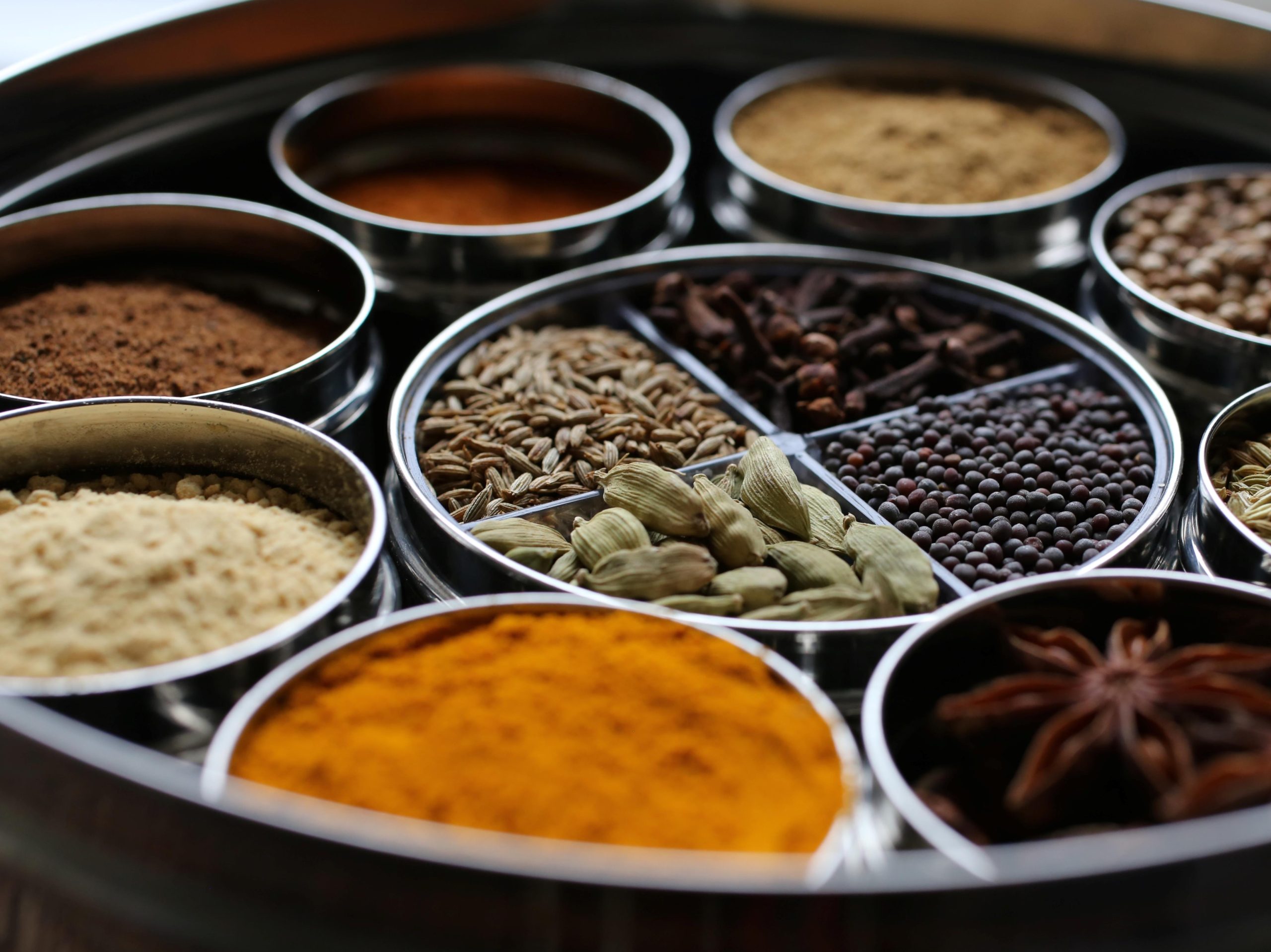 a spice tin filled with ground and whole spices