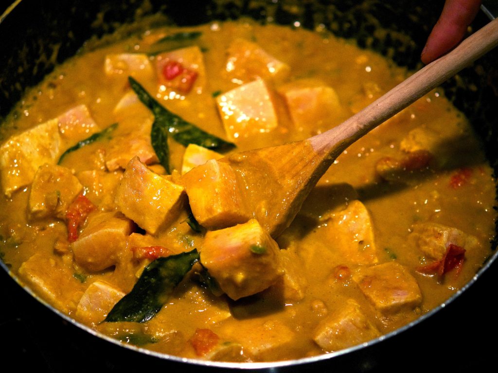 fish in coconut milk being cooked in a kadai