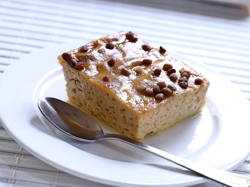 a serving of baked egg custard on a plate, with a spoon