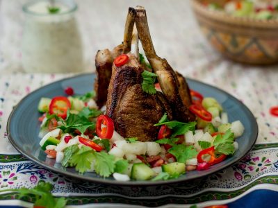 three barbecued lamb cutlets on a bed of kachumber