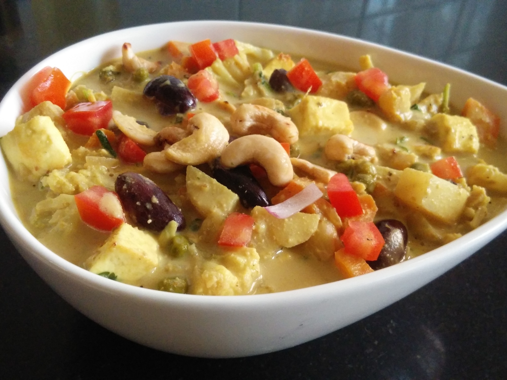 a serving bowl of mixed vegetable korma