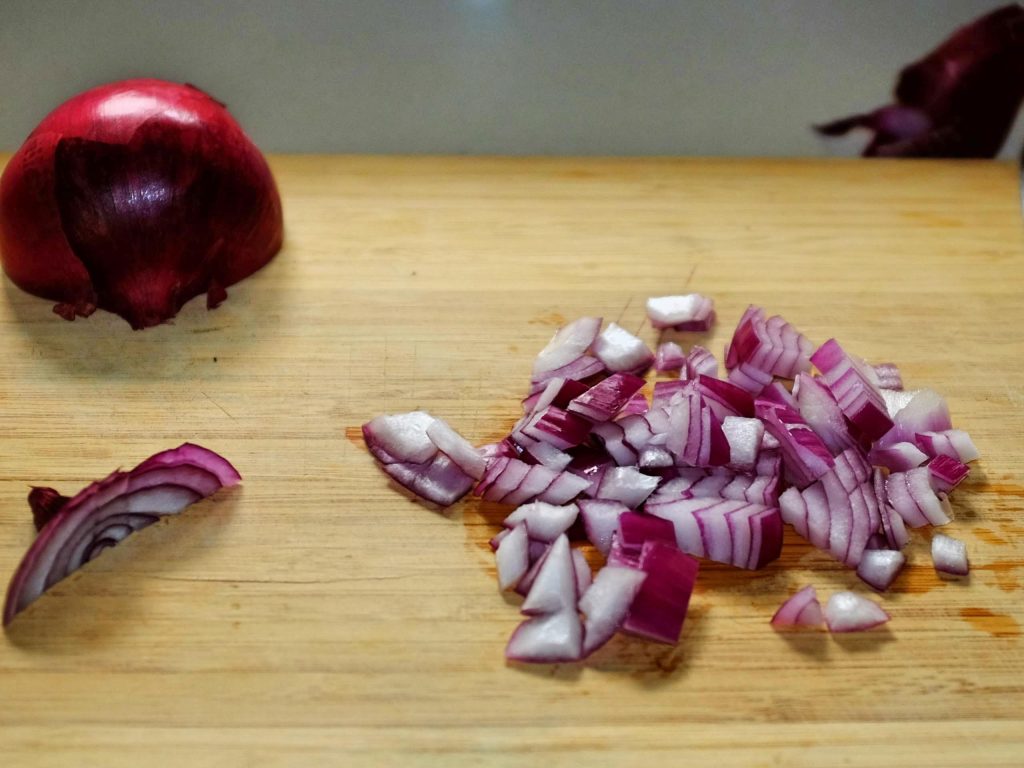how to chop onions A mound of chopped onion with stem end shown at side