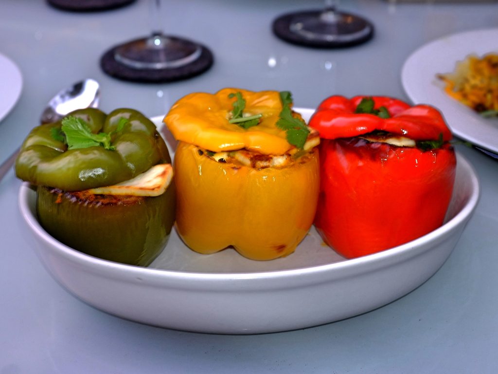 three differently coloured capsicums stuffed with paneer