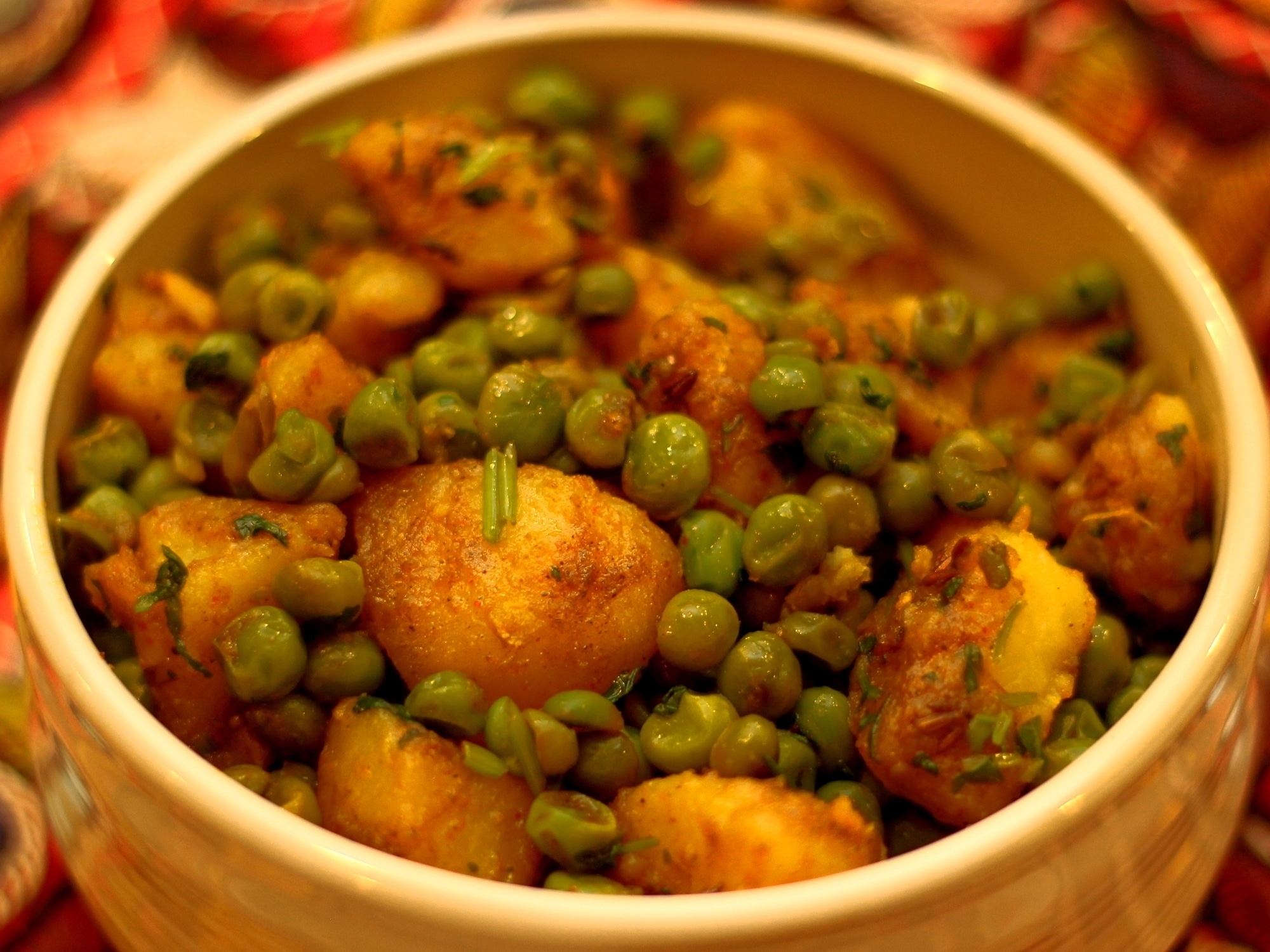 a serving bowl of dry potato and pea