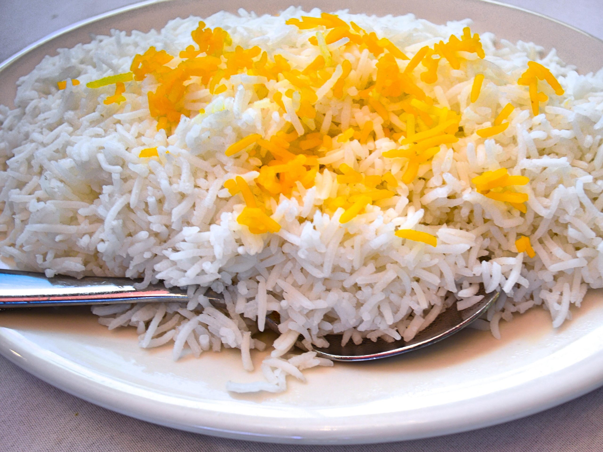 a bowl of cooked basmati rice, with some yellow rice decoration