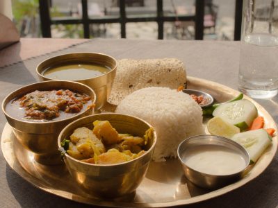 a simple vegetarian thali - bowls of rice, dal, vegetable curry and accompaniments on a serving platter