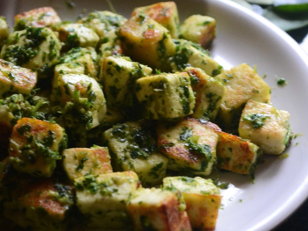 paneer tikka, marinated in green chutney, on a serving plate
